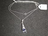 un collier en argent auquel est suspendue une pierre bleue