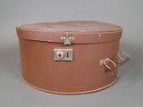tan leather suitcase with a lock on top of it on a gray surface