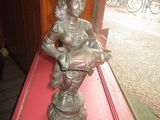a statue of a woman holding a book on a red table