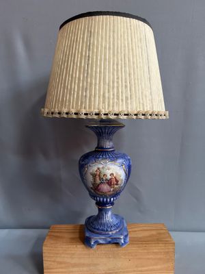 une image représentant une lampe bleue surmontée d'un abat-jour blanc