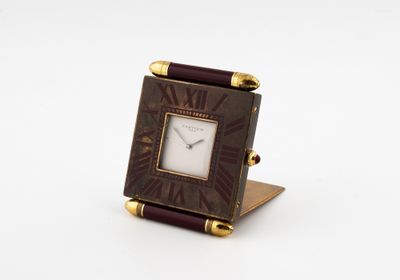 an image of a small square clock with roman numerals on the face