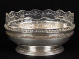 un plat ancien en argent avec un bol en verre sur fond noir