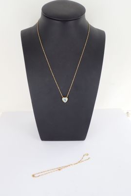 un collier composé d'une chaîne en or et d'une pierre verte