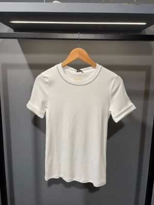 un t-shirt blanc suspendu à un cintre dans une armoire