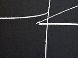 black and white photograph of a cross drawn on a black surface