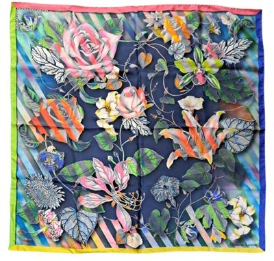 un gros plan sur un foulard carré orné de fleurs et de feuilles