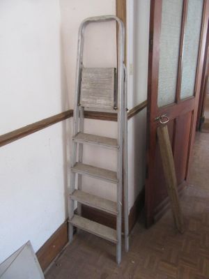 une échelle appuyée contre un mur, à côté d'une porte