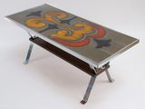 a glass table with a painting on it on a stand