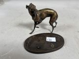 une statue représentant un chien, située à côté d'une plaque commémorative
