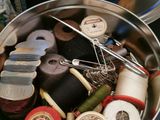 many different types of sewing thread in a metal container