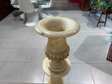un vase posé sur un socle au milieu d'une pièce