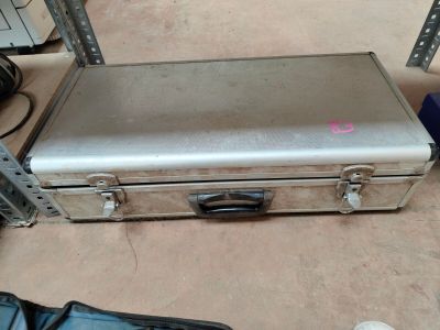 a metal case sitting on the floor next to a pair of shoes