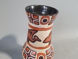 a small vase with a design on it on a table