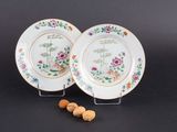 deux assiettes ornées de fleurs et d'oiseaux, posées sur une table