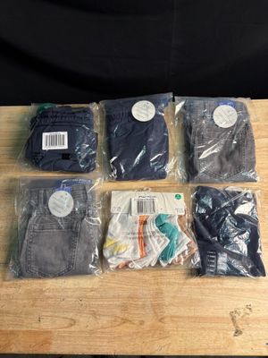 six paires de jeans pour homme, dans des sacs, posées sur une table