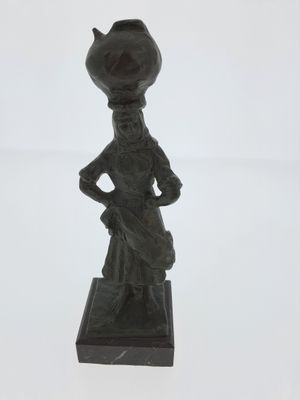une image représentant une statue d'une femme portant un pot sur la tête
