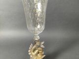 a glass vase with a bird on it on a table