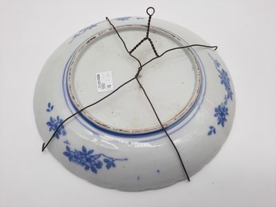 une assiette bleue et blanche entourée d'un fil métallique