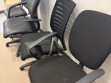 four office chairs are lined up against a wall in a room