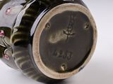 a close up of a vase with a clock on it