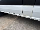 a white truck with a black stripe parked on the side of the road