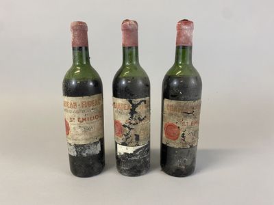 three bottles of wine are lined up on a white surface