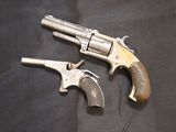 two old revolvers on a black cloth with a black background