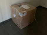 une boîte en carton posée sur une autre boîte en carton, par terre
