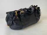 a black purse with gold hardware on the handles