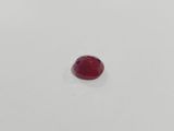 a single red stone on a white surface