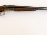 gros plan d'un fusil sur une surface blanche