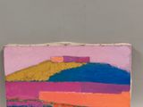 painting of a colorful landscape on a piece of wood with a candle