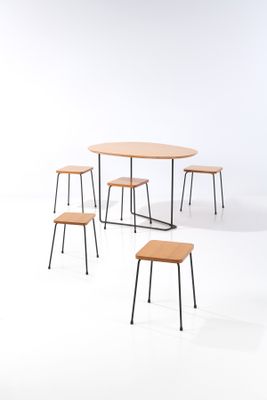 a group of four tables and four stools in a white room