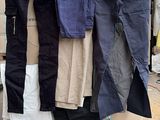 de nombreux pantalons de différentes couleurs posés sur une palette dans la rue