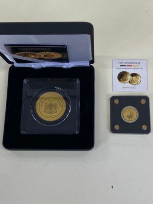 une pièce d'or dans une boîte noire, avec une carte à côté