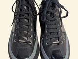 pair of black sneakers with black laces on a white background