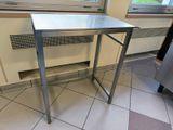 a stainless steel table in the corner of a kitchen