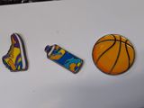 three magnets on a refrigerator with a basketball shoe, basketball ball, and spray can