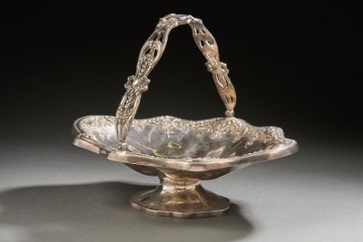 an antique silver plated bowl with a handle on a stand