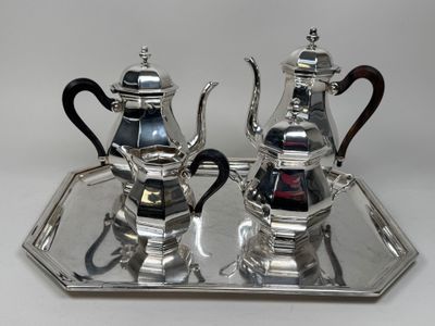 two silver teapots on a silver tray on a table