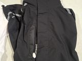 a black jacket and a white shirt laying on a bed