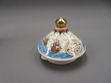 an image of a small white and blue vase with a ship on it