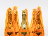 trois bouteilles de champagne sont alignées sur une surface blanche