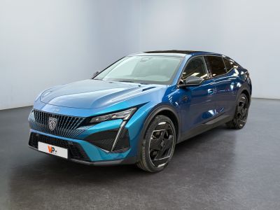 Une voiture bleue est garée dans une grande pièce au sol noir.