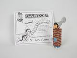 une petite figurine représentant un homme debout sur un mur de briques
