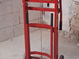 a red hand truck that is sitting in a room