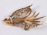 an image of a gold and diamond broochle on a white surface