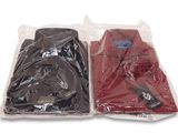 deux vêtements emballés dans des sacs en plastique, posés sur une surface blanche