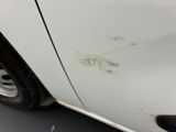 a white car that has some rust on the side of it