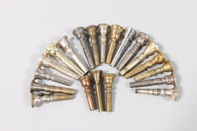 a lot of different types of brass pipes on a white surface